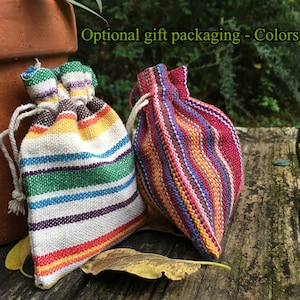 Peut inclure: Deux petits sacs &agrave; cordon color&eacute;s avec des motifs &agrave; rayures. L'un des sacs pr&eacute;sente un arc-en-ciel de couleurs, dont le rouge, le jaune, le vert et le bleu. L'autre sac est principalement rouge avec des rayures bleues et jaunes. Le texte "Optional gift packaging - Colors vary" est visible.