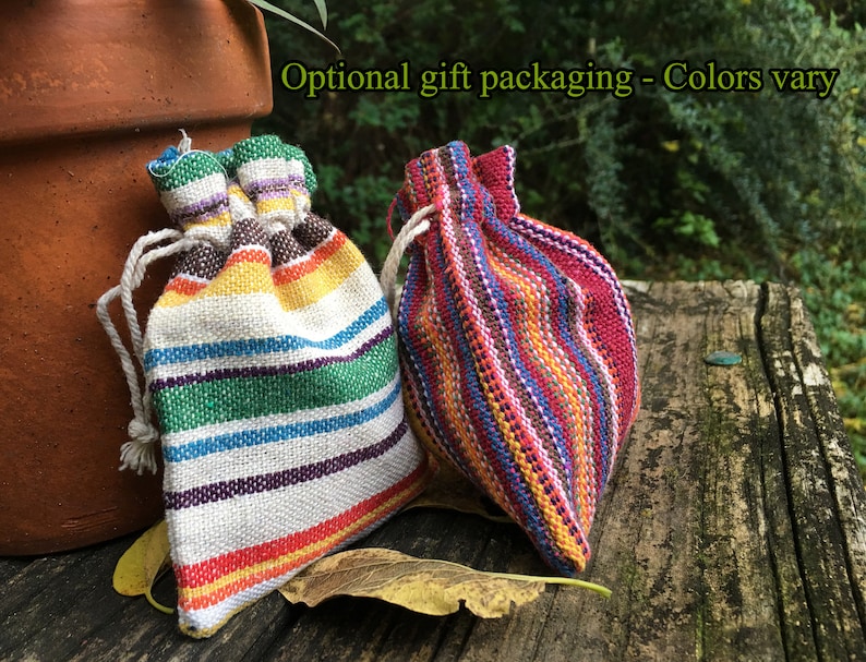 Peut inclure: Deux petits sacs &agrave; cordon color&eacute;s avec des motifs &agrave; rayures. L'un des sacs pr&eacute;sente un arc-en-ciel de couleurs, dont le rouge, le jaune, le vert et le bleu. L'autre sac est principalement rouge avec des rayures bleues et jaunes. Le texte "Optional gift packaging - Colors vary" est visible.