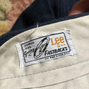 May include: A white label with blue and gold text and a graphic of a shoe. The label reads "Geared for Going Lee Fastbacks Lic Pat 2,978,422".