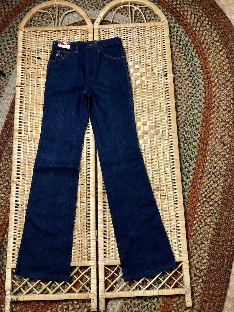 May include: A pair of dark blue denim jeans with a high waist and a bootcut leg.
