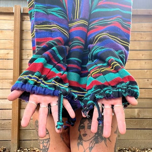 May include: A colourful striped sweater with a zip fastening and drawstring ties at the cuffs. The sweater is made from a soft, comfortable fabric and has a relaxed fit.