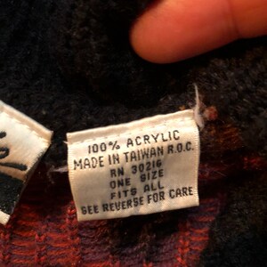 May include: White tag with black text that reads "100% Acrylic Made in Taiwan R.O.C. RN 30216 One Size Fits All See Reverse for Care"