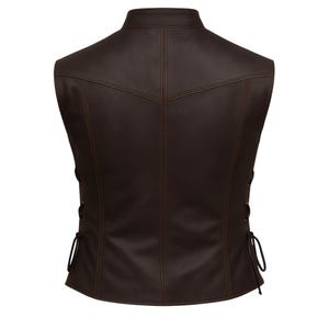 May include: A brown leather vest with a mandarin collar and decorative stitching. The back of the vest features a tailored design with vertical seams and side laces for adjustment. The vest is a solid color and has a classic, timeless style.