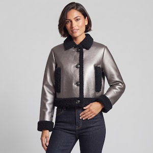 May include: A metallic silver cropped jacket featuring a black faux shearling collar, cuffs, and front trim. The jacket has a button-down front closure with four dark buttons and two vertical black faux shearling pockets on the front panels.