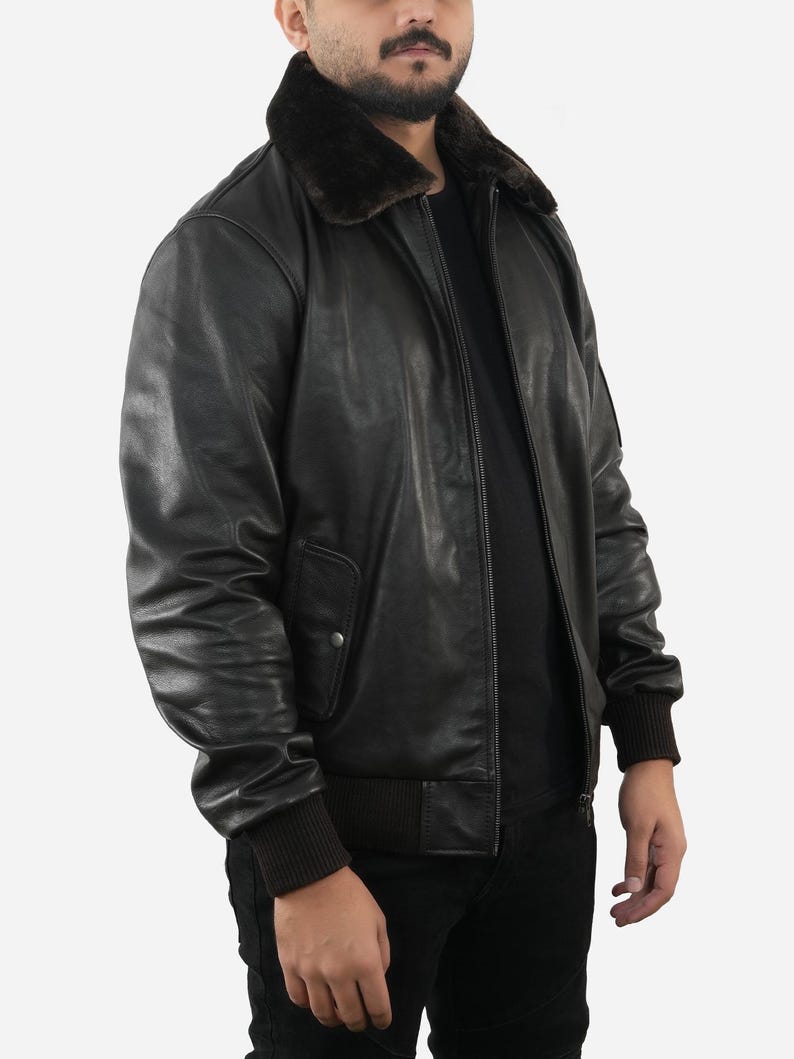 May include: Black leather bomber jacket with a brown faux fur collar. The jacket features a zip-up front, ribbed cuffs, and a ribbed hem. The jacket has a classic, timeless design.