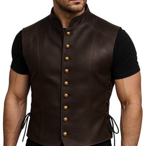May include: A brown leather vest with a mandarin collar and gold-colored buttons. The vest has decorative stitching and side laces. The vest is a classic style.