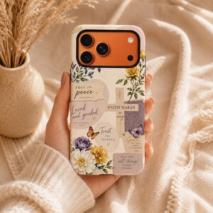 May include: A phone case with a cream background featuring floral illustrations, butterflies, and a cross. Text includes "Pray in peace," "Loved and guided," "Faith makes a way," "Trust the journey," "Grace," and "With God, all things become possible."