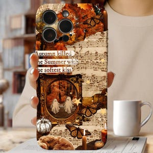 May include: A phone case with a collage design featuring autumn leaves, butterflies, musical notes, and a framed image of two ghosts. The case has the text "Autumn killed the Summer with the softest kiss."