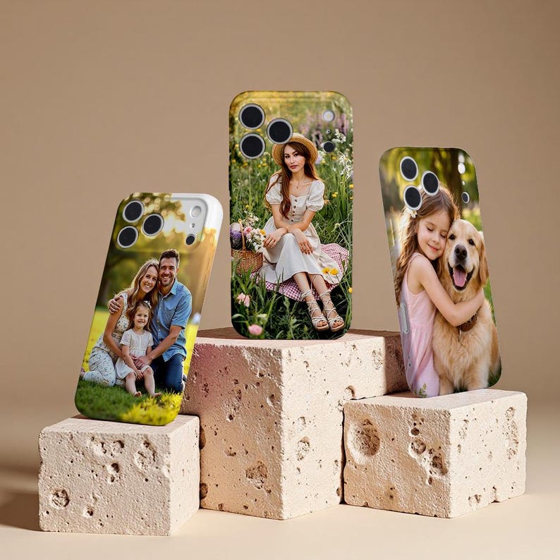 May include: Three phone cases with custom photos displayed on textured, beige blocks. The cases feature family portraits and a woman in a field. The cases have a glossy finish and are designed to protect the phone.