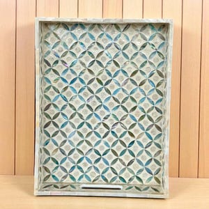 May include: Rectangular decorative tray with a mother-of-pearl inlaid border and a geometric pattern of blue, green, and white circles. The tray has a recessed handle and is set against a light wood background.