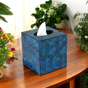 Puede incluir: Tapa de caja de pañuelos azul con un patrón hexagonal. La tapa está hecha de un material que se asemeja a azulejos de mosaico.