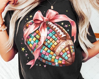 May include: A black t-shirt with a colorful mosaic football design and a pink bow. The football is decorated with stars and glitter.