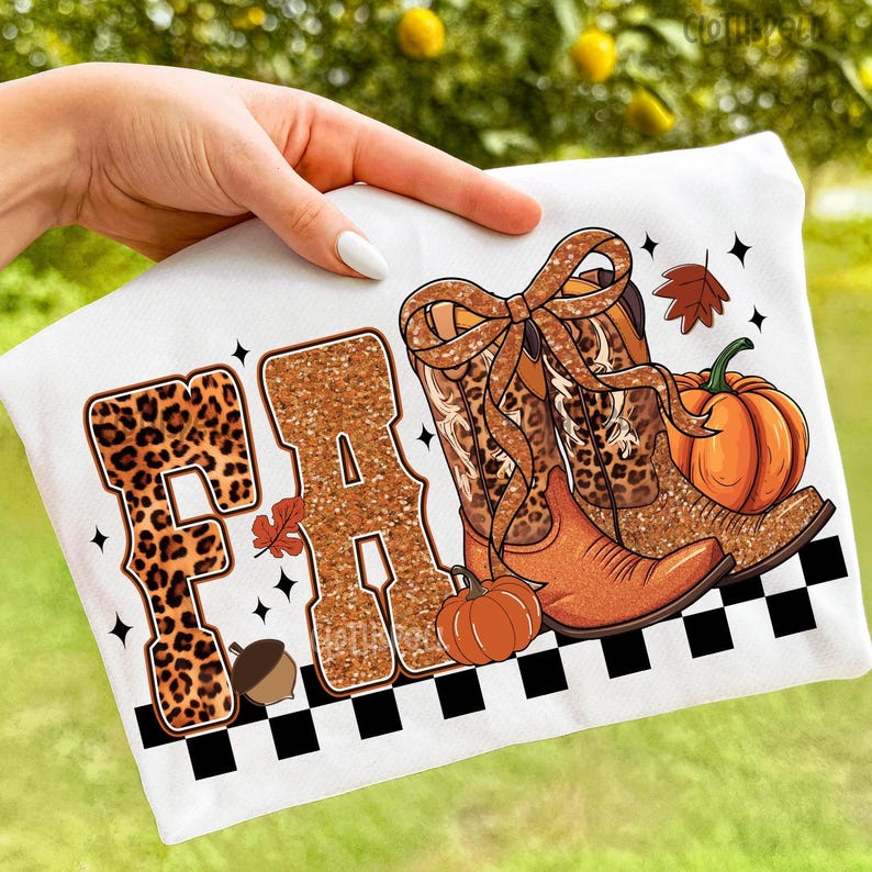 Peut inclure: T-shirt blanc avec un motif sur le th&egrave;me de l'automne. Le mot "FALL" est affich&eacute; avec des lettres &agrave; imprim&eacute; l&eacute;opard et remplies de paillettes. Bottes de cowboy, citrouilles et feuilles compl&egrave;tent le design, avec une bordure &agrave; carreaux noirs et blancs.