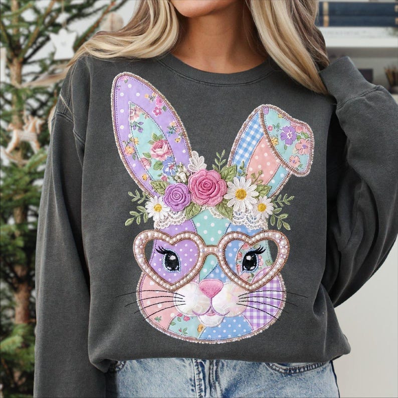 Puede incluir: Sudadera gris oscuro con un dise&ntilde;o de conejo de retazos. El conejo tiene gafas en forma de coraz&oacute;n y una corona floral. El patchwork incluye patrones rosas, morados, azules y blancos. Un estilo casual y c&oacute;modo.