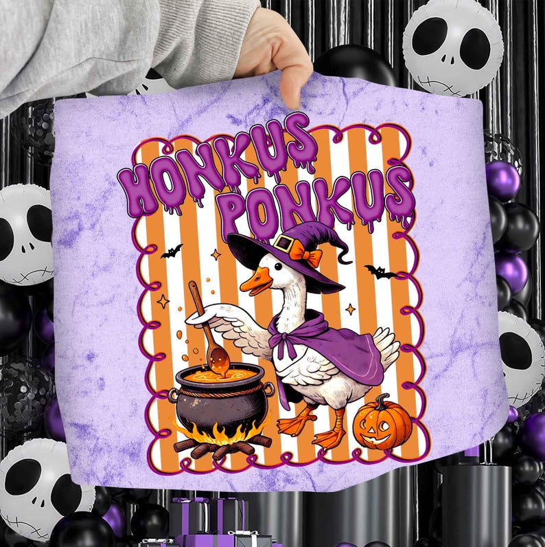 May include: A Halloween-themed design featuring a goose in a witch's hat and cape, stirring a cauldron. The design includes the text "HONKUS PONKUS" in purple, with orange and white stripes in the background, and a pumpkin.