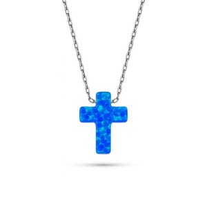 Puede incluir: Collar de cadena plateada con un colgante de cruz azul brillante. La cruz es de color azul vibrante con una apariencia texturizada, similar al ópalo. El collar es una joya sencilla y elegante.