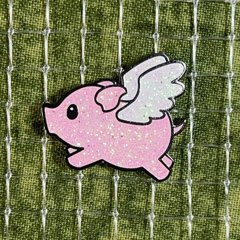 May include: A pink glitter pig with white glitter wings. The pig is flying and has a black outline.