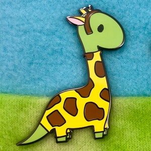 May include: A green and yellow enamel pin of a cartoon giraffe with brown spots. The giraffe is wearing a green hat and has a pink ear.