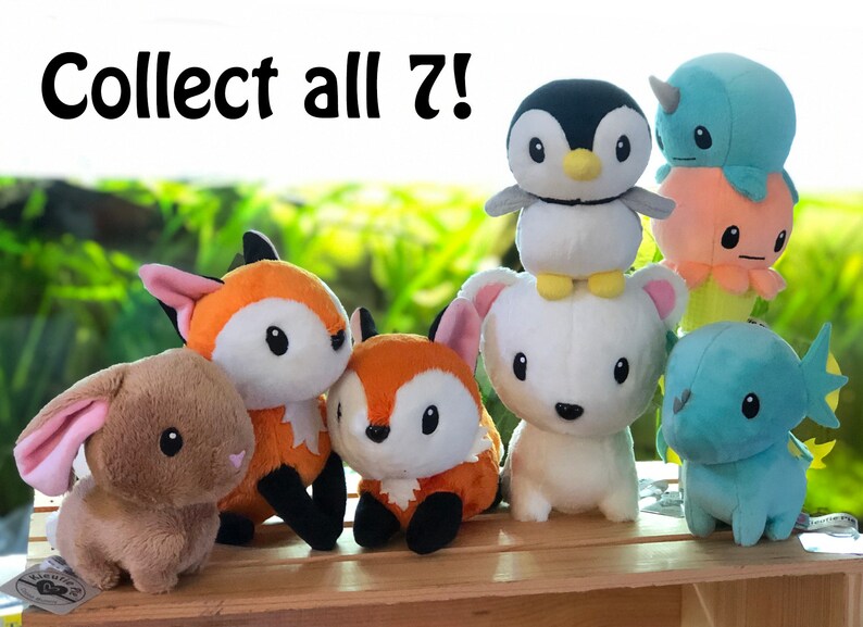 May include: A collection of seven plush toys, including a penguin, a narwhal, an octopus, a fox, a rabbit, and a dragon. The toys are all sitting on a wooden crate. The text "Collect all 7!" is written above the toys.