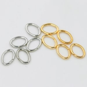May include: A collection of oval jump rings in gold and silver. The rings are approximately 10mm in diameter.