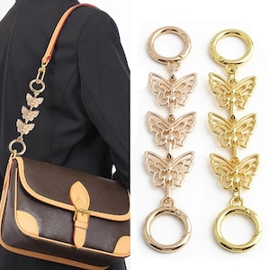 Peut inclure: Breloque de sac en forme de papillon doré avec deux clips pivotants. Le charme présente trois maillons en forme de papillon et est un accessoire élégant pour les sacs et les sacs à main.