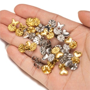 Pode incluir: Conjunto de fechos para brincos em ouro e prata em forma de borboleta, coração e redondo.