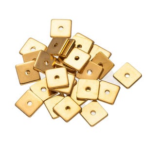 Könnte beinhalten: Ein Haufen goldfarbener quadratischer Metallperlen mit einem Loch in der Mitte jeder Perle.