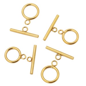 May include: Five gold-toned metal toggle clasps for jewellery making. Each clasp features a round ring and a straight bar.