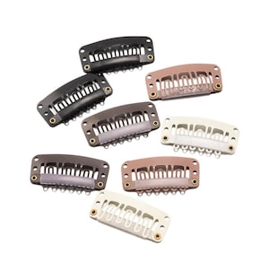 May include: Assortment of hair clips in various colors, including black, brown, and white. The clips are made of metal and have a comb-like design.