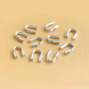 Puede incluir: Cuentas de crimpado de metal plateado, también conocidas como tubos de crimpado, se utilizan para asegurar los hallazgos de joyería y crear un acabado profesional. Estas cuentas son pequeñas y tienen forma de U.