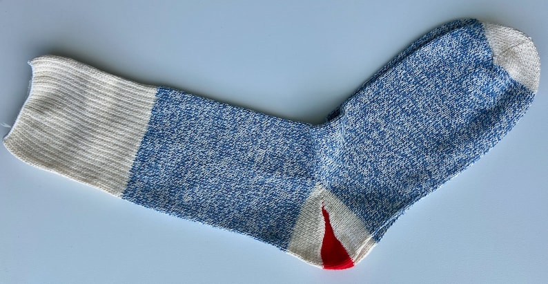 Puede incluir: Un calcet&iacute;n azul y blanco con tal&oacute;n y puntera rojos. El calcet&iacute;n tiene un patr&oacute;n moteado.