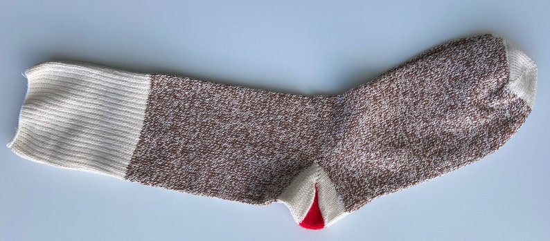 Puede incluir: Un calcet&iacute;n marr&oacute;n y blanco con un tal&oacute;n rojo. El calcet&iacute;n tiene un patr&oacute;n de punto texturizado.