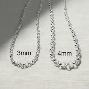 May include: Two silver-coloured chain necklaces, one labelled "3mm" and the other "4mm". The chains are made of small, interconnected circular links. The necklaces are displayed against a light background.