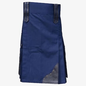Puede incluir: Un kilt azul marino con detalles de cuero negro. El kilt presenta pliegues, bolsillos y correas de cuero en la cintura. La esquina inferior tiene un parche decorativo de cuero con ojales metálicos. Prenda tradicional.