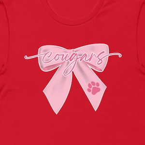 COUGARS Bow Shirt, PINK BOW, Coquette Spirit Wear, School Spirit, Mascot Bow, Pink Out, Cheer Bow, Football Bow Shirt, Bella Unisex camiseta