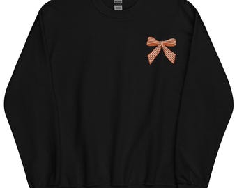 Puede incluir: Sudadera negra con un lazo a rayas marrón y naranja en el pecho izquierdo.