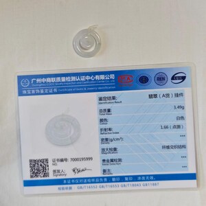 May include: A translucent white jade pendant shaped like a circular ring with a smaller center disc, accompanied by a rectangular identification certificate featuring blue borders, text in Chinese and English, and a total mass of 3.49g.
