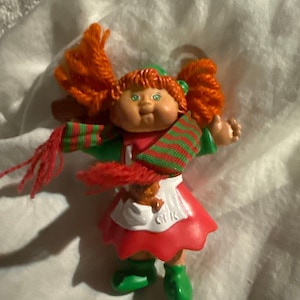 May include: A set of three ceramic mugs with a speckled, matte finish. The mugs are in shades of cream, light gray, and dark gray. Each mug has a simple, minimalist design, perfect for coffee or tea.