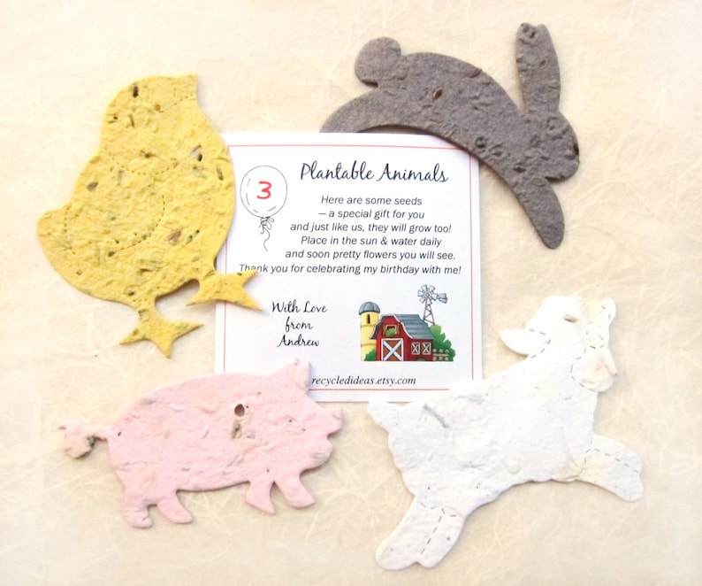 Puede incluir: Favores de papel de semillas de animales plantables en forma de pollito, conejo, cordero y cerdo. El papel es de color amarillo claro, gris, blanco y rosa. La tarjeta dice "Animales plantables" e incluye instrucciones para plantar las semillas. La tarjeta tambi&eacute;n dice "Con amor de Andrew" y "recycledideas.etsy.com".