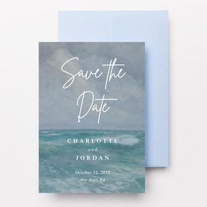 May include: A wedding invitation with a watercolor ocean scene. The invitation card features the text "Save the Date" in elegant script, along with the names "Charlotte and Jordan" and the date "October 12, 2033". A light blue envelope is behind the card.