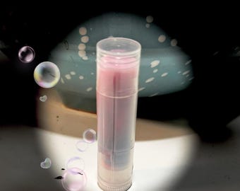 May include: A clear tube lip balm with a pink and purple color gradient.