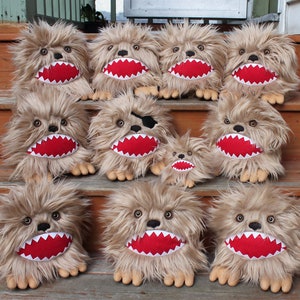 May include: A group of 11 plush toys with brown fur, red mouths, and white teeth. The toys are arranged in a staircase formation. Some of the toys have black eyes, while others have brown eyes. One toy has a black eye patch.