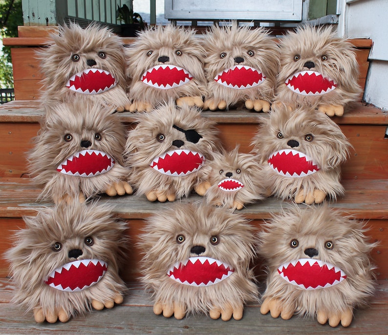 May include: A group of 11 plush toys with brown fur, red mouths, and white teeth. The toys are arranged in a staircase formation. Some of the toys have black eyes, while others have brown eyes. One toy has a black eye patch.