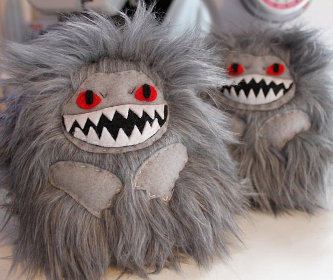 grey stuffed monster with teeth