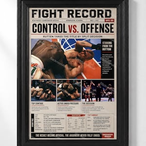 May include: A framed poster titled FIGHT RECORD featuring a collage of mixed martial arts match photographs, text detailing the UFC 20 event, Bas Rutten versus Kevin Randleman, fight statistics, and a summary of the match outcome in a black frame.