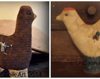 May include: Two handmade fabric chickens, one brown and one white, with red accents on their heads. Both chickens have a pin stuck in their back, suggesting they are pincushions. The brown chicken is sitting on a wooden surface, while the white chicken is hanging from a wooden surface. The image includes the text "© T.F.C. Folk Art 2014".