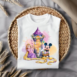 May include: White t-shirt with a colorful illustration of Rapunzel and Mickey Mouse decorating a tower with Easter eggs.