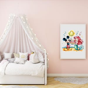 May include: A white framed print featuring a cartoon illustration of Mickey Mouse and Ariel the Mermaid celebrating a birthday with a cake and a star-shaped balloon. The background is a light blue watercolor wash.