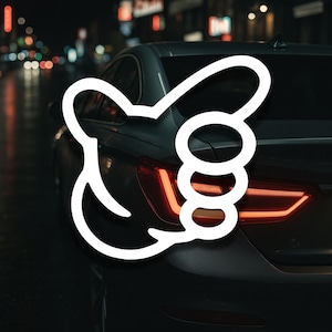 May include: A white thumbs-up graphic superimposed on the rear of a dark grey car. The car's rear lights are illuminated, and the background shows city lights at night, suggesting movement and approval.