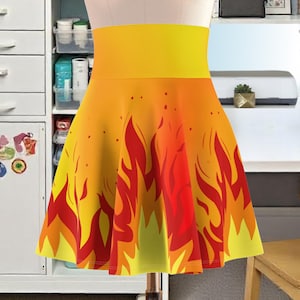 May include: A yellow and red skater skirt with a flame pattern. The skirt has a high waist and a flared silhouette.